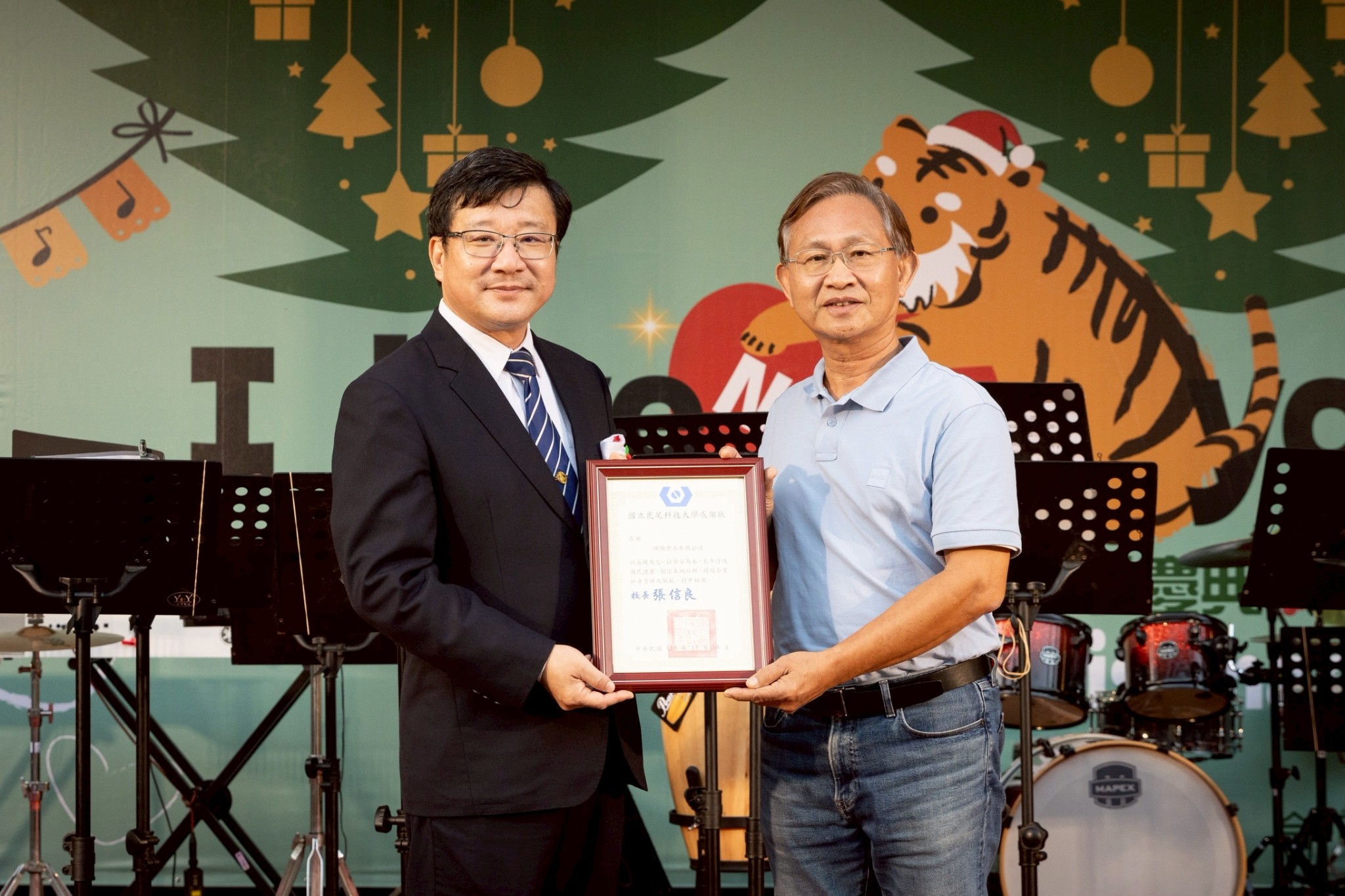 President Shinn-Liang Chang (left) presents a letter of appreciation to Chuan-pin Wu (right), General Manager of Yuanshun Foods, thanking the company for participating in NFU's public welfare initiative.